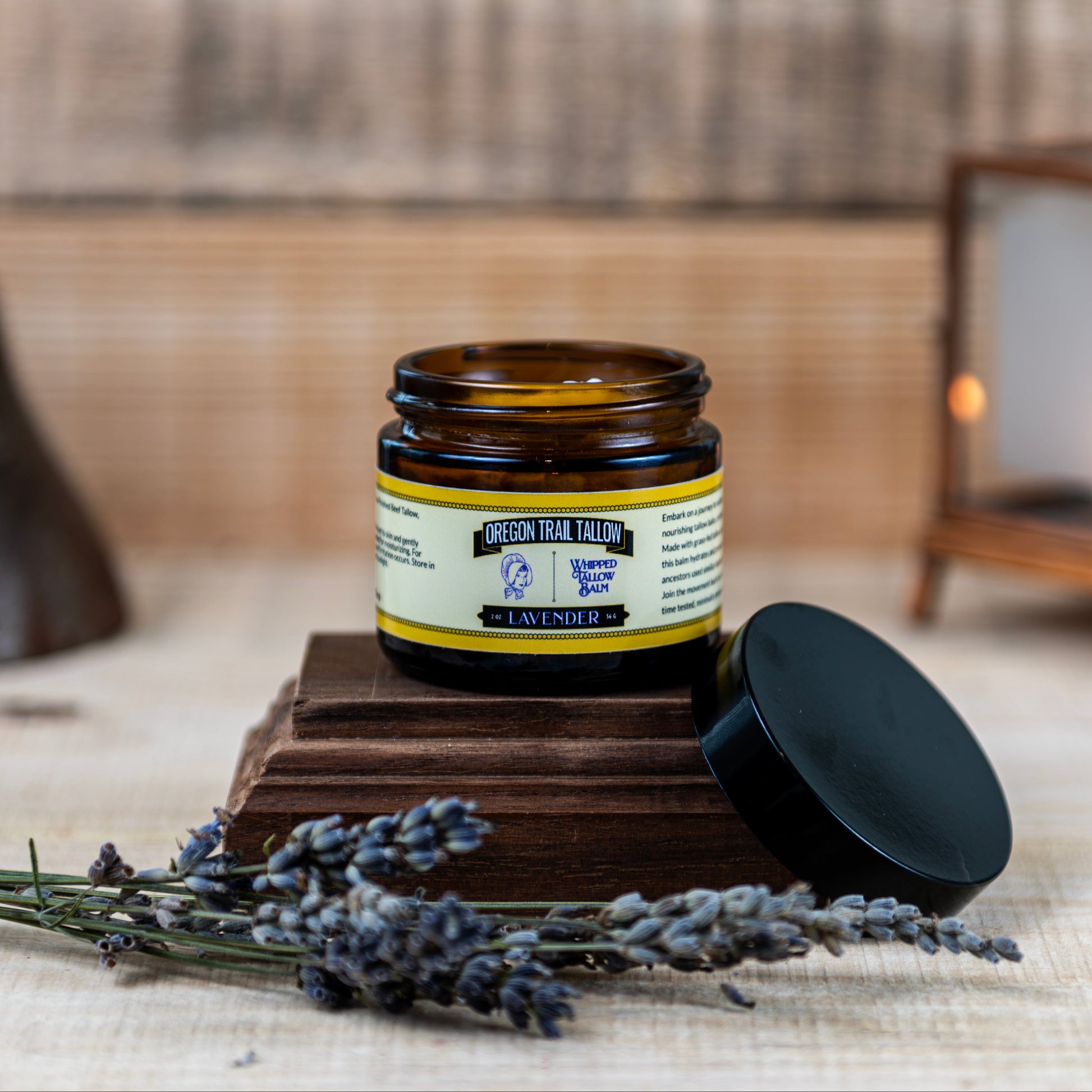 Jar of lavender product on a wooden block with lavender flowers and a rustic background
