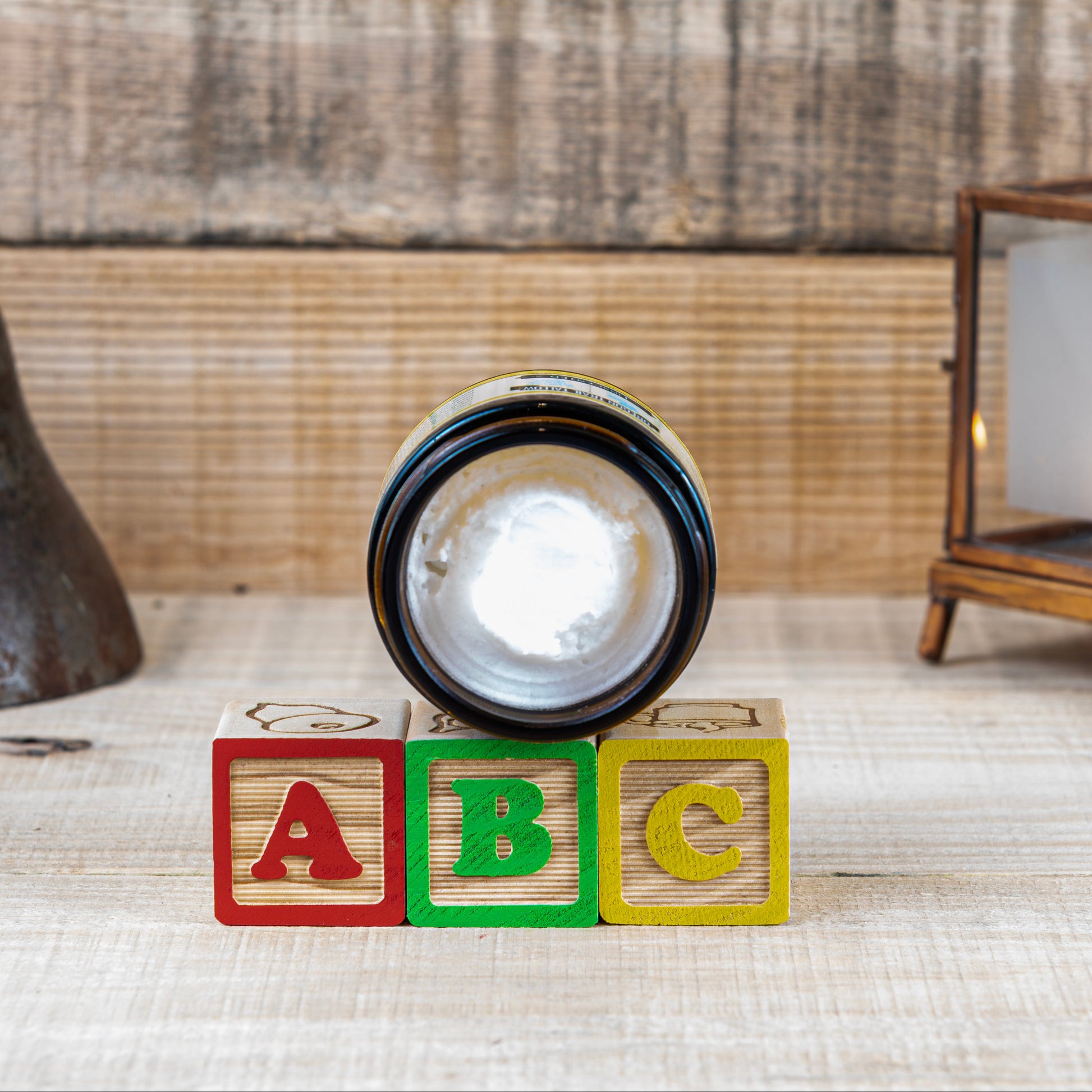 Decorative setup with wooden blocks, bell, and lantern on a textured surface.